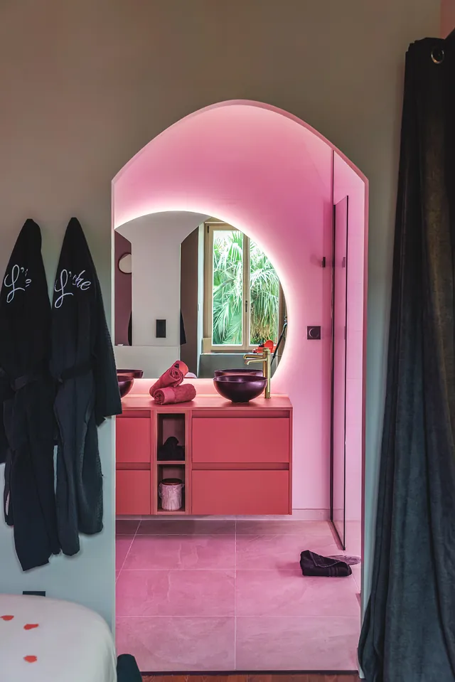 Arche lumineuse ouvrant sur la salle de bain, peignoirs brodés suspendus