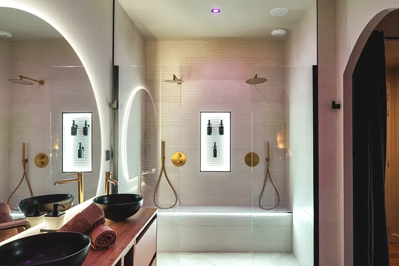 Double douche à l'italienne, vasques noires et miroir en arche