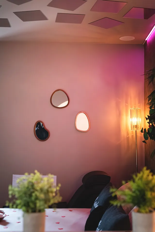 Miroirs galets et lumière rosée au-dessus du lit